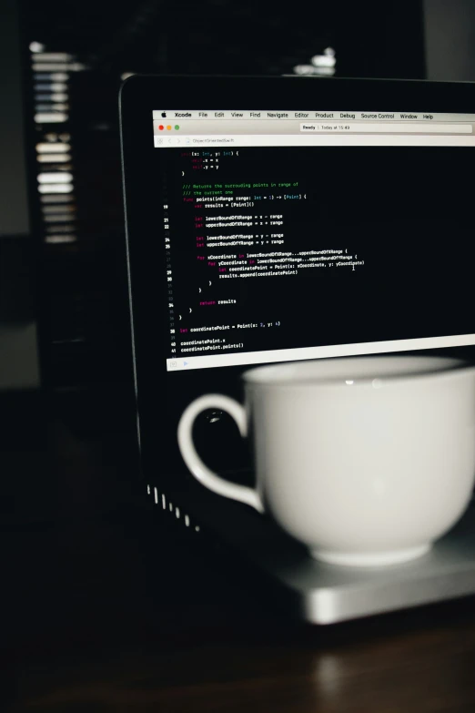 black and white pograph of coffee in front of a computer screen