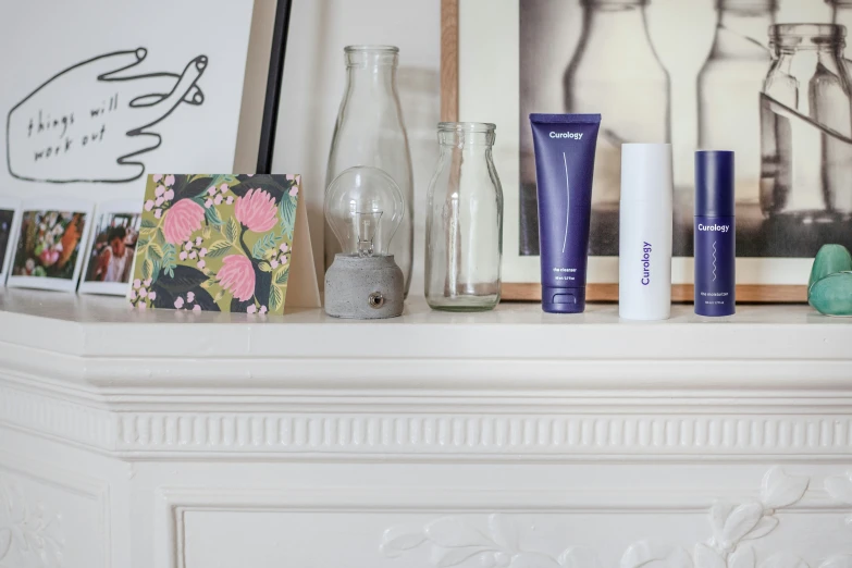 a fireplace mantel topped with a bottle and various personal care products