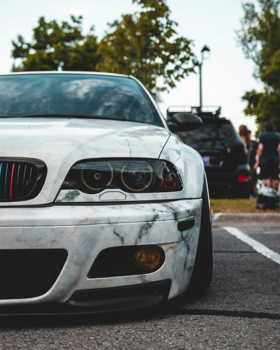 a dirty white car that is sitting in the street