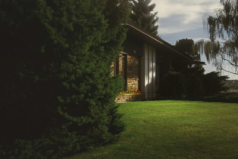 an old brick building sitting on the side of a lush green field