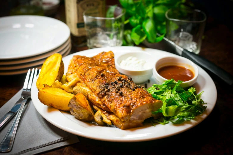 a dinner plate contains meat, potatoes and herbs