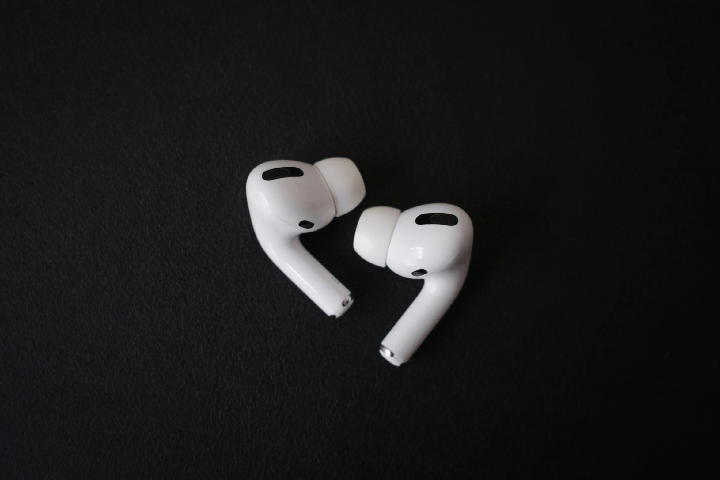 a pair of white earbuds laying on top of each other