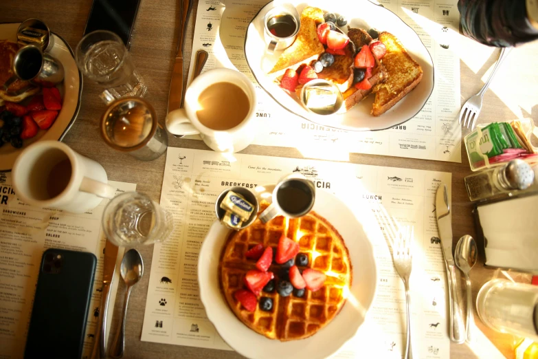 a waffle cut into four pieces with fruit on top