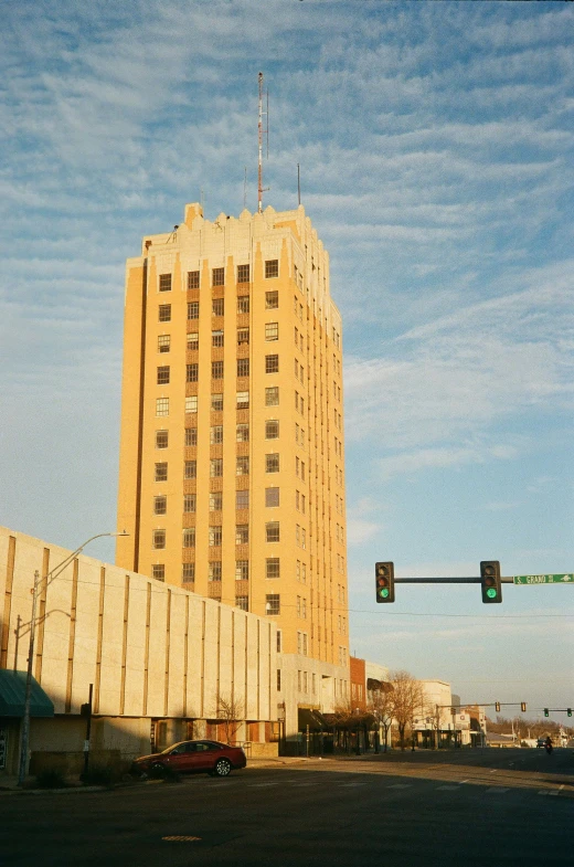 there is a traffic light on the street in front of a tall building