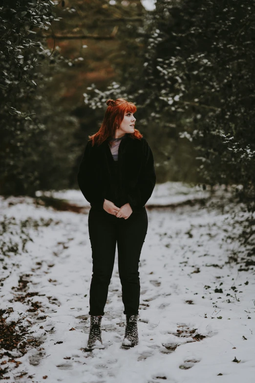 the woman is standing in the snow with her hands on her hips