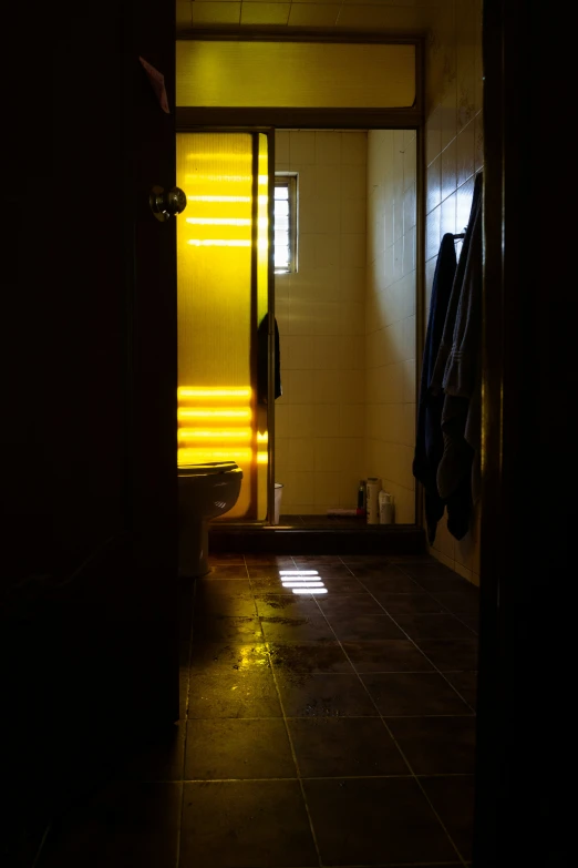 a hallway with a lit up door and yellow blinds