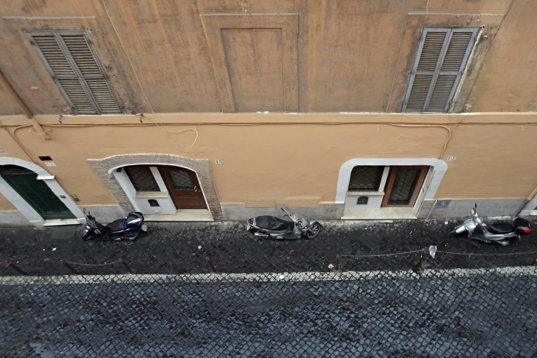 two motorcycles parked in front of a brick building