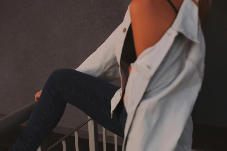 a woman is posing with her foot propped on the rail