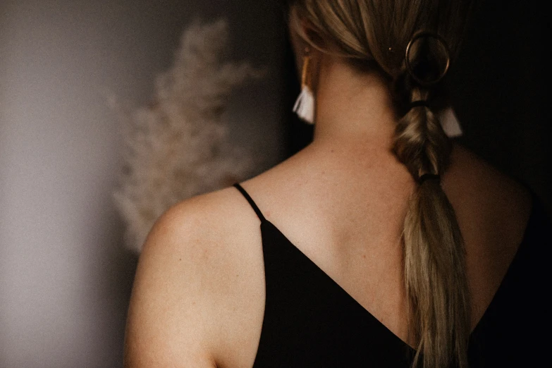 a woman with a very long ponytail in a black dress