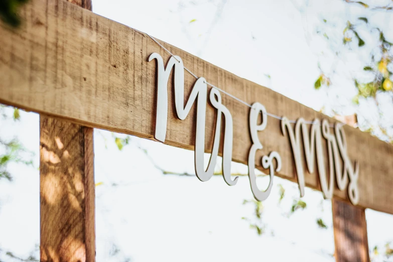 a wooden sign with the word mr and mrs hanging from it