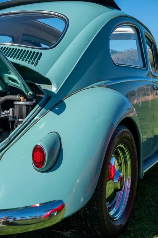 the hood of a large blue car that has its engine exposed