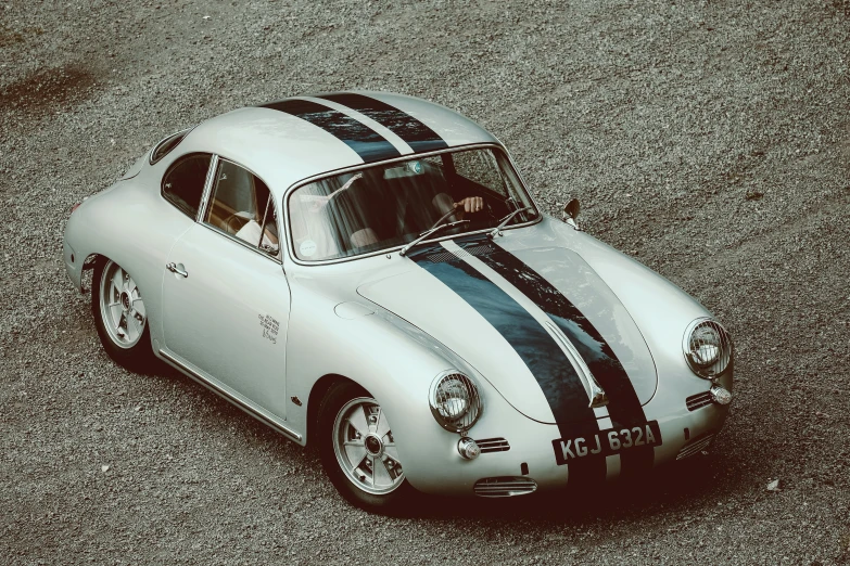 a small silver sports car with black and white stripes