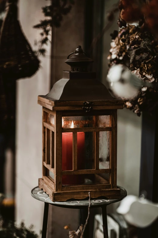 the candle light is on a small table in front of plants