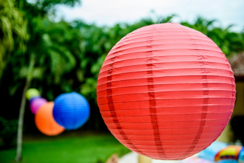 a pink paper lantern sitting on top of a white post