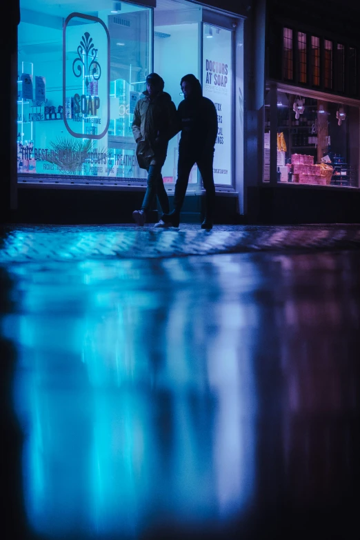 a couple standing next to a store with an umbrella