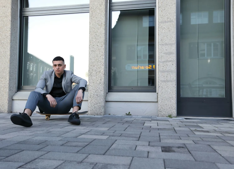 man sitting on curb with skateboard looking at the camera