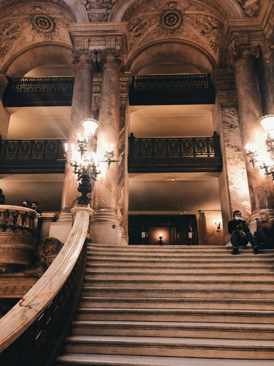 a large stone building with steps and chandeliers