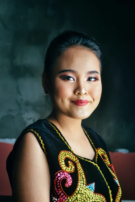 a woman with very long black hair and a colorful top smiling