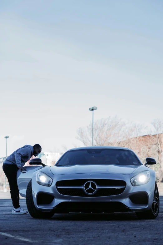 a man bending down and examining his car
