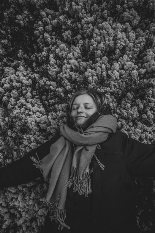 a woman laying down on her side with a scarf around her neck