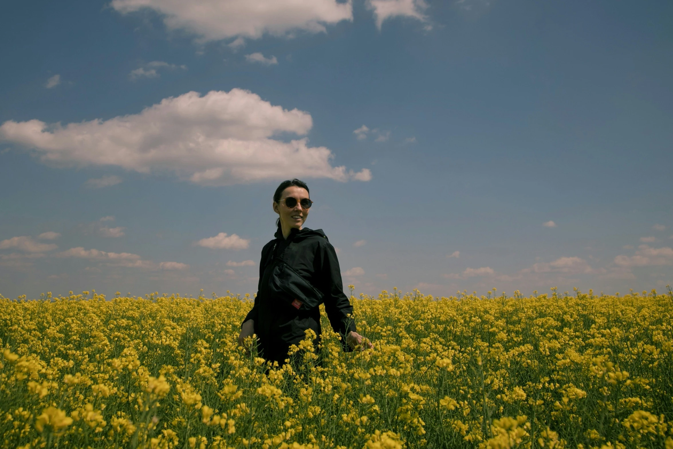 a man stands in a yellow flower field