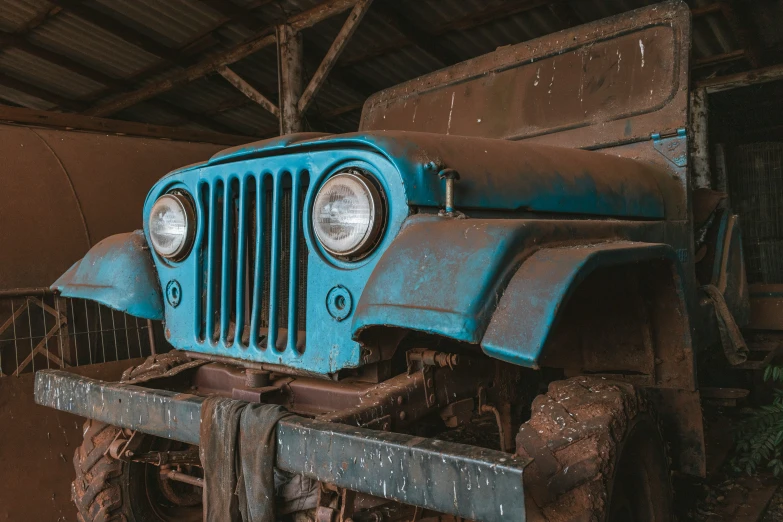 an old blue truck parked in a barn