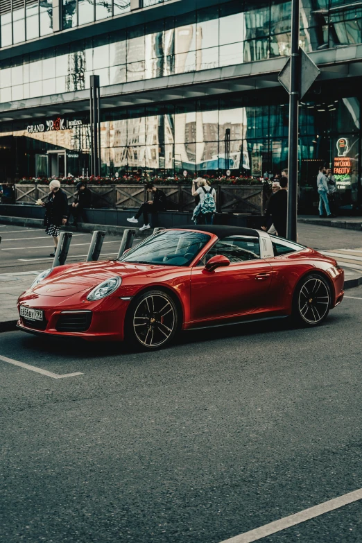 a red sports car drives down the street