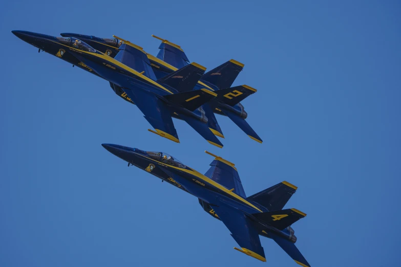 four navy blue angel planes flying close together