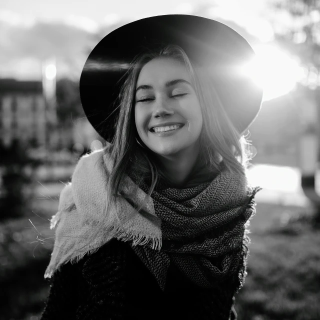 a woman wearing a black hat and scarf posing for a picture