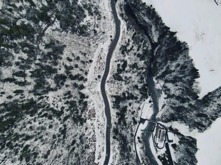 an aerial view of a snowy area with trees and a house