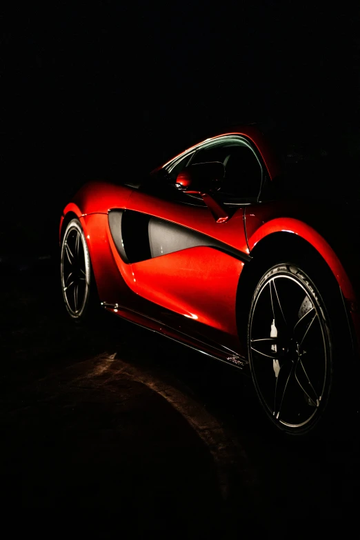 a car is pictured lit up on the dark floor