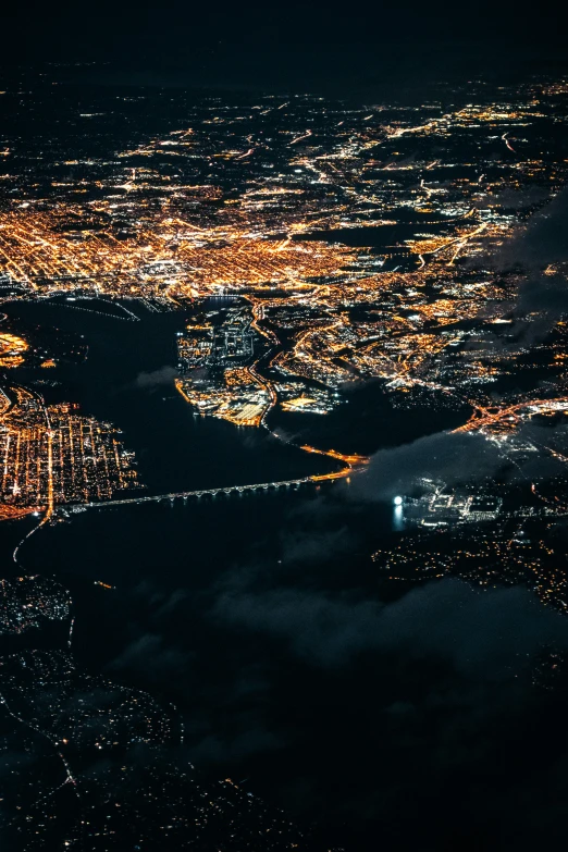 an aerial view of the lights of cities on water and in air at night