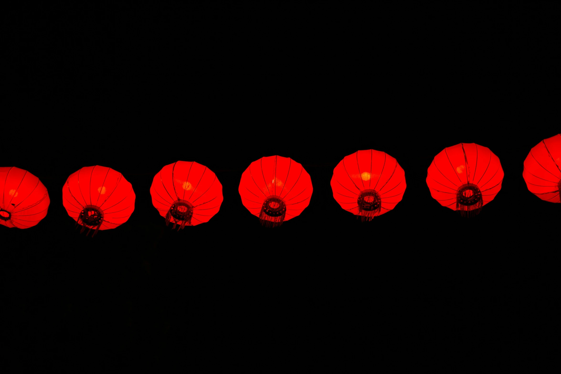 several red chinese lanterns in rows with black background