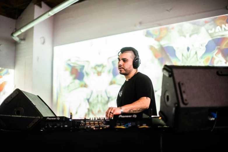 a man is playing electronic music in front of a projection
