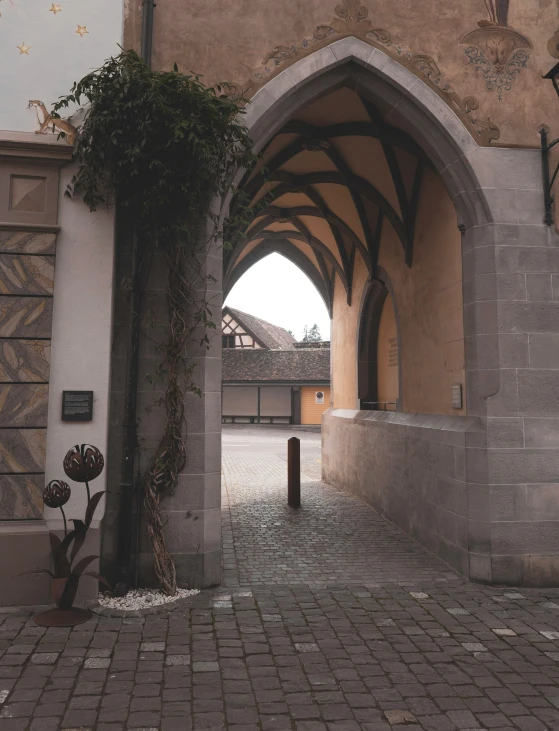 an archway in a stone building with brick pavement