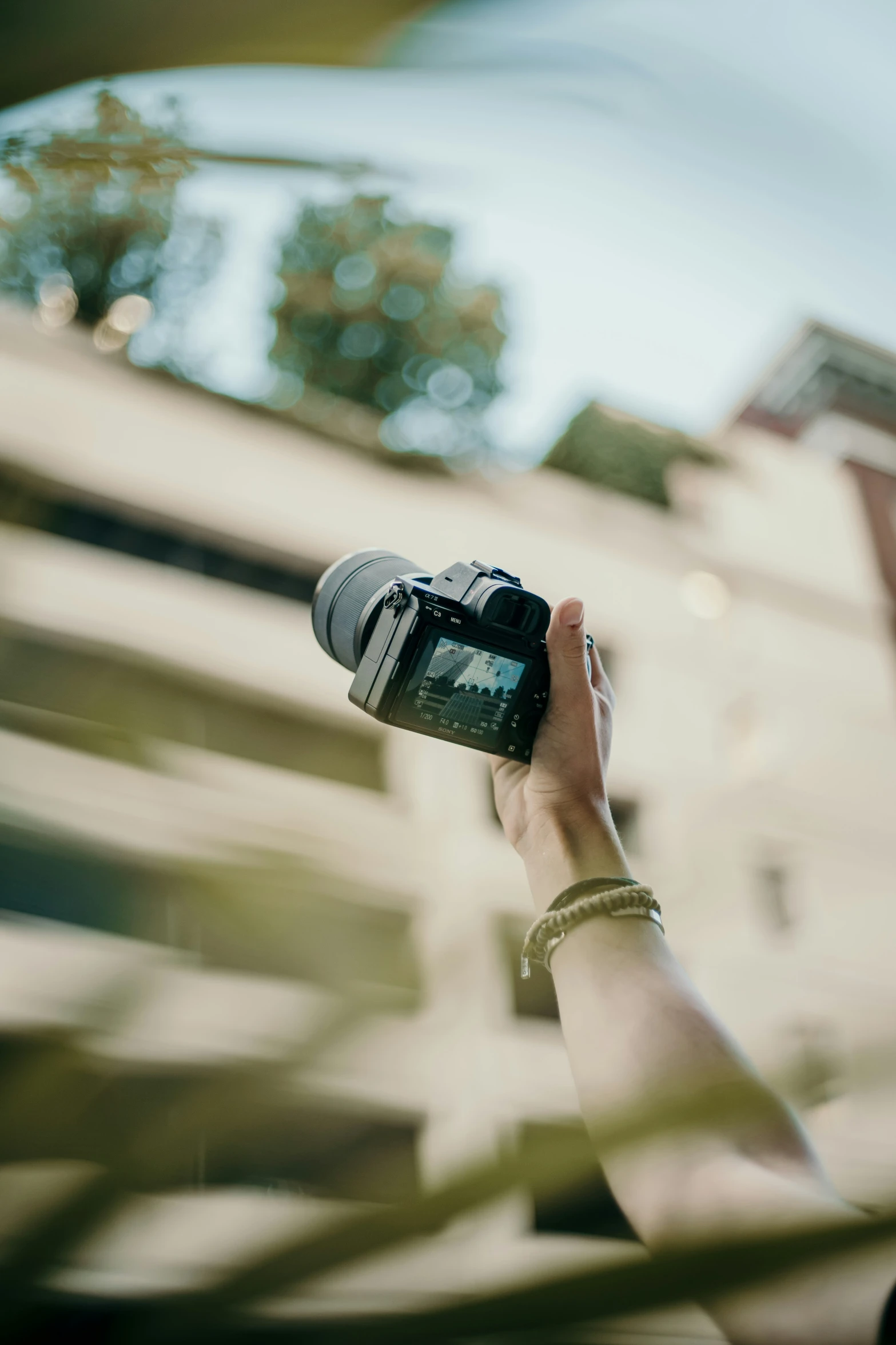 person taking pograph with camera in public with buildings