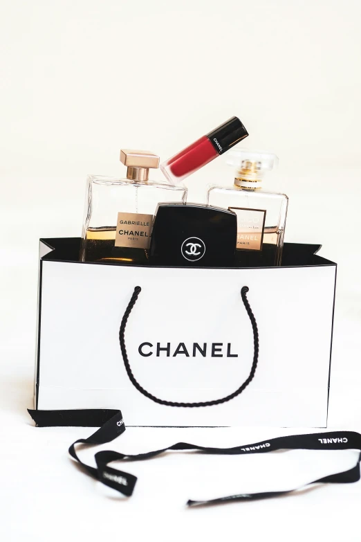 an open bag with a small package containing lipstick and perfume