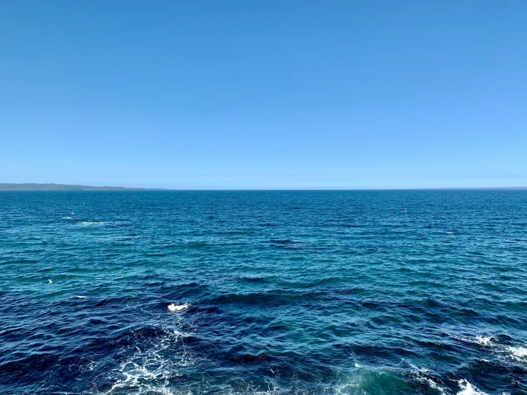 the view from the ocean waves with blue sky and hills in the distance