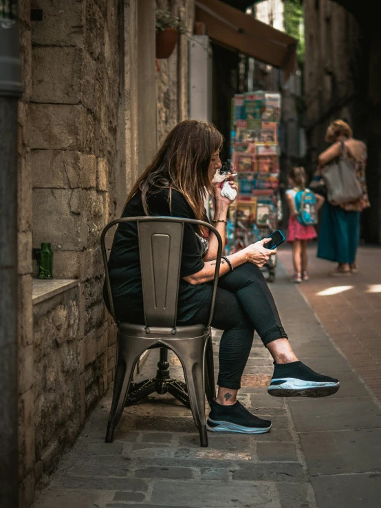 a woman sitting on an open chair and drinking coffee