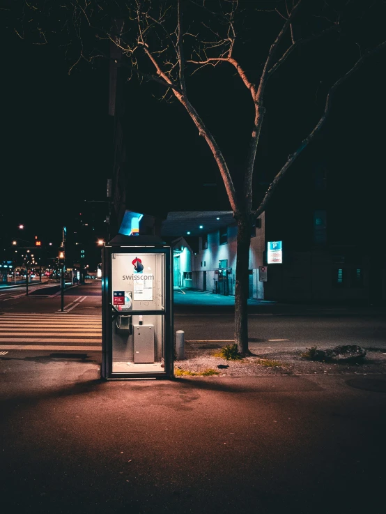 an old - fashioned machine sits on the curb in front of a tree