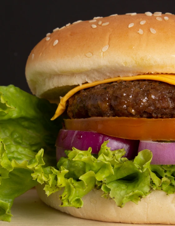 a burger sitting on top of a wooden  board