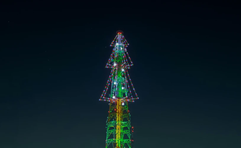 the top of a tall building is lit up with multicolored lights