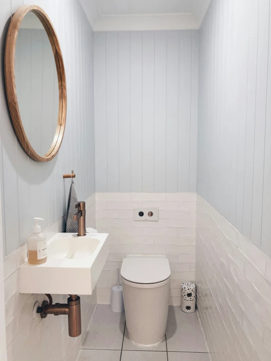 this bathroom has a toilet, sink and a mirror