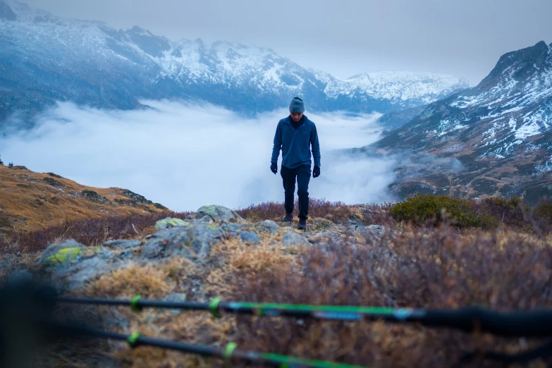 a man standing on top of a hill near a mountain