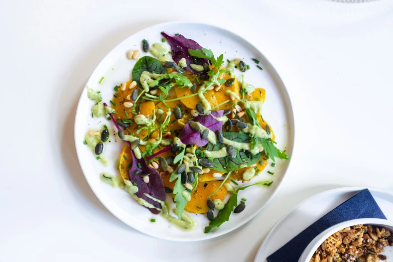 a plate full of food and a bowl filled with vegetables