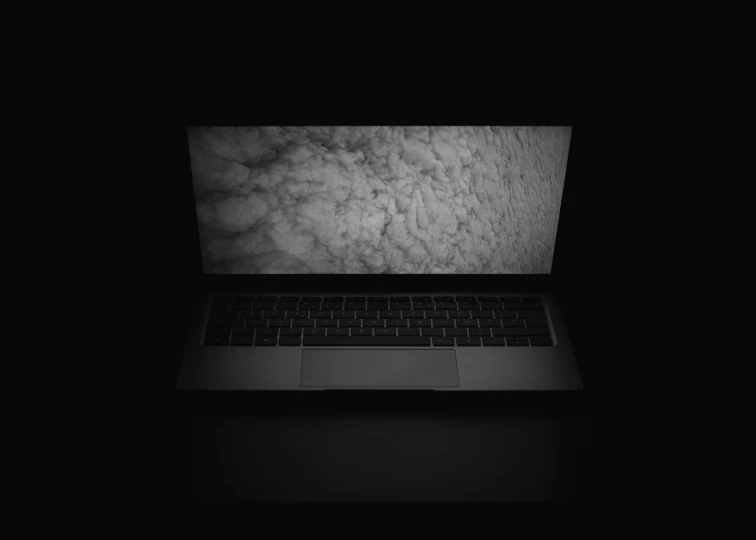 a laptop in the dark with clouds on the screen