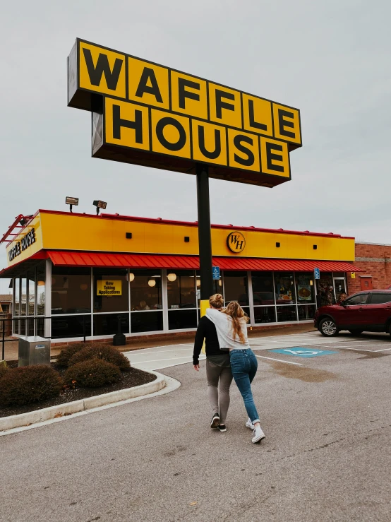 two people crossing the street by a waffle house