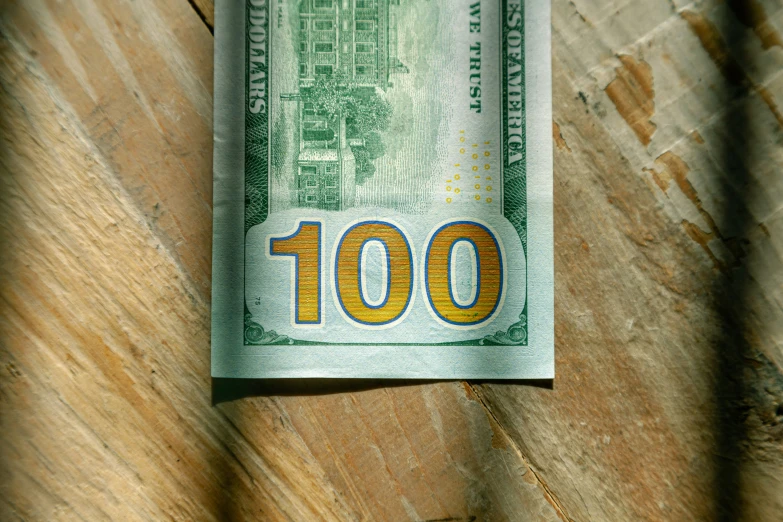 a dollar bill with the word 100 displayed