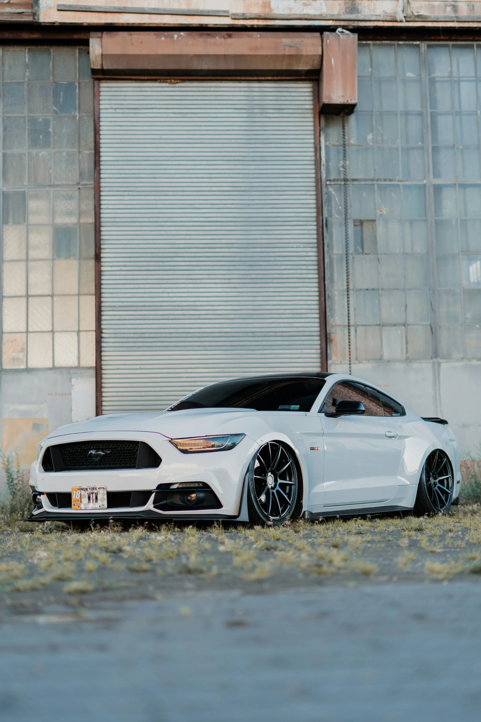 the ford mustang is parked in front of an old building