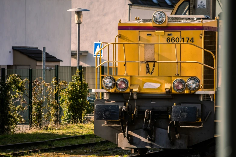 a yellow train car sitting on the tracks
